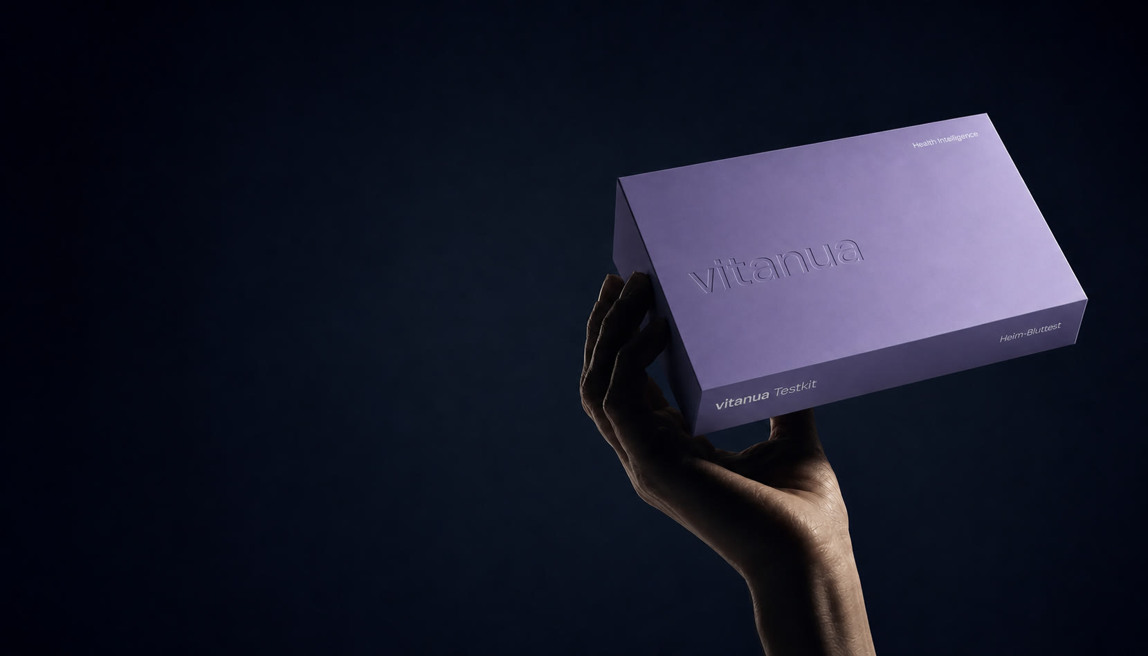 Hand hält das einheitlich gestaltete violette vitanua Testkit vor dunklem Hintergrund